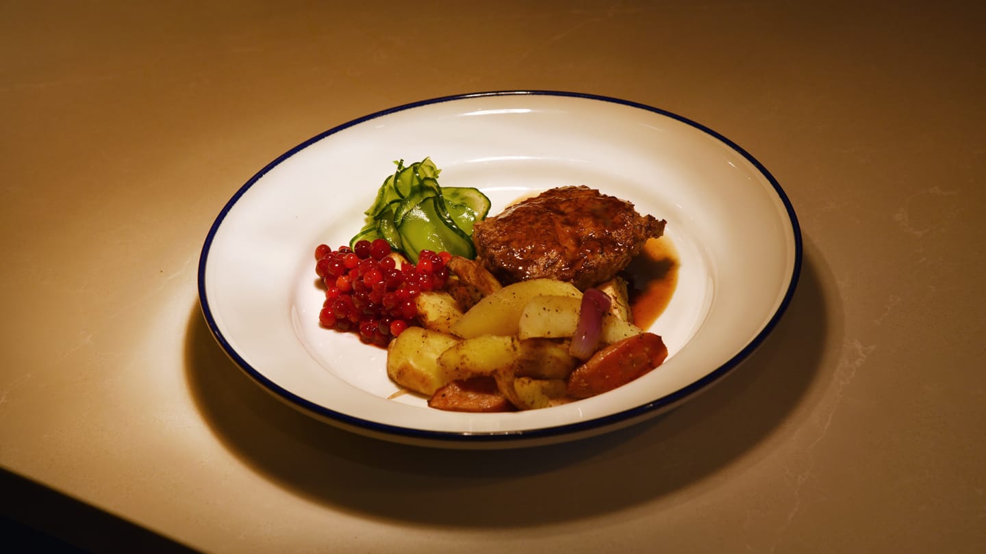 Pannbiff på kornbulgur med lingon, picklad gurka, rotfrukter och rödvinssky