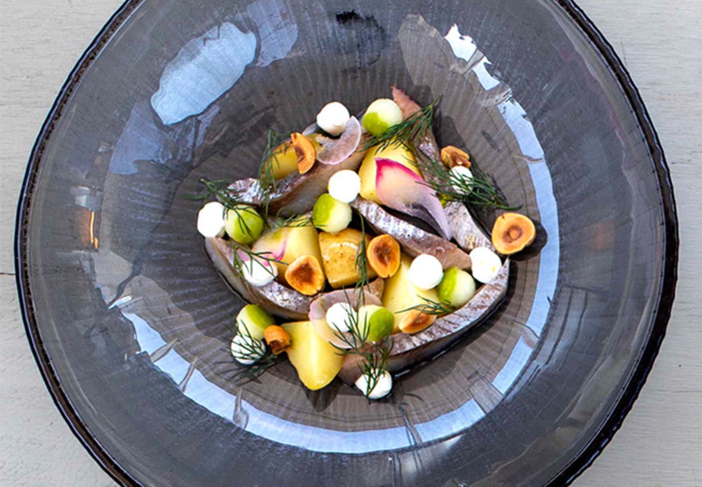 Matjessill med potatis, hängd gräddfil, rostade hasselnötter och svenska äpplen