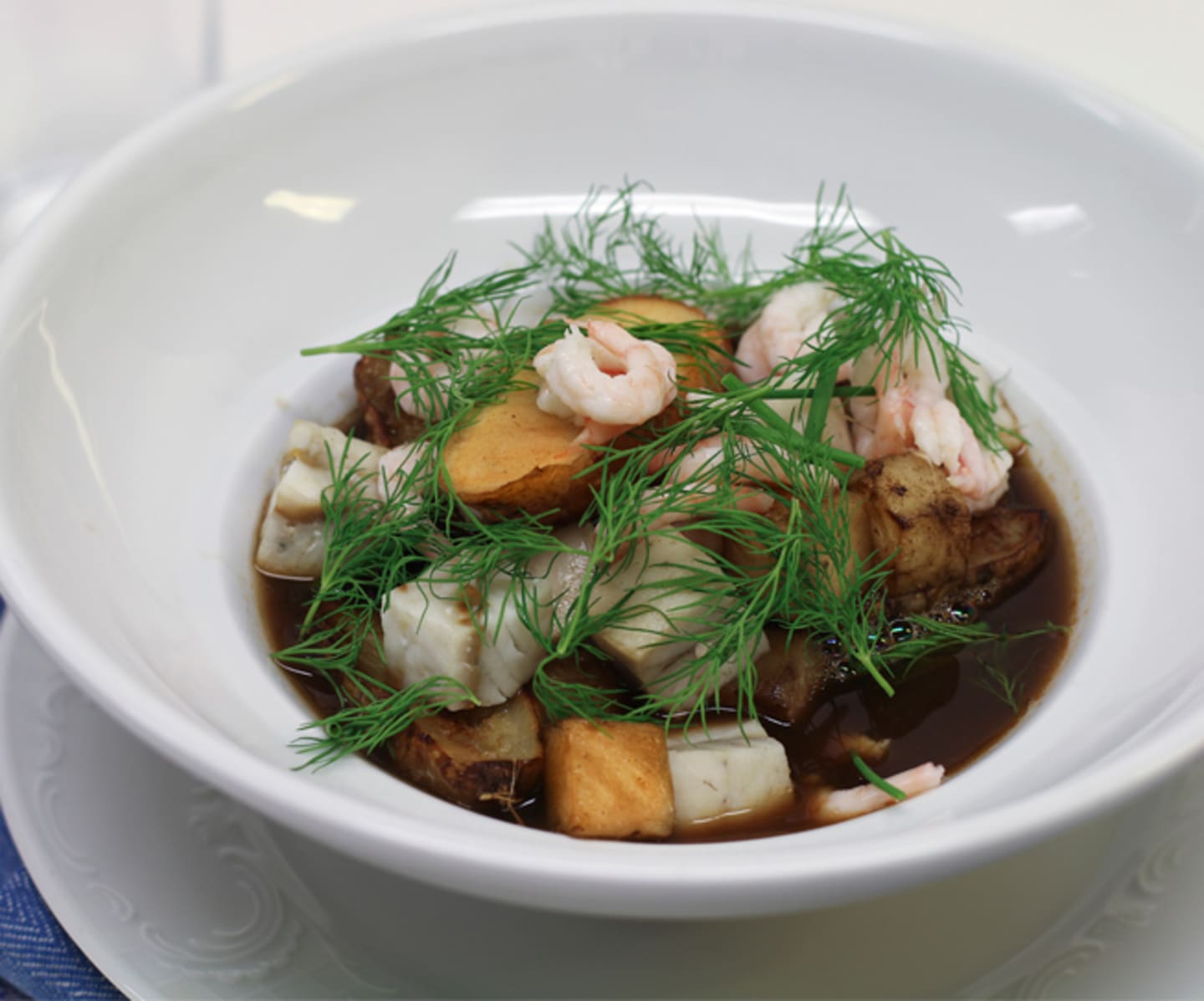 Klar skaldjurssoppa med rotfrukter och örter